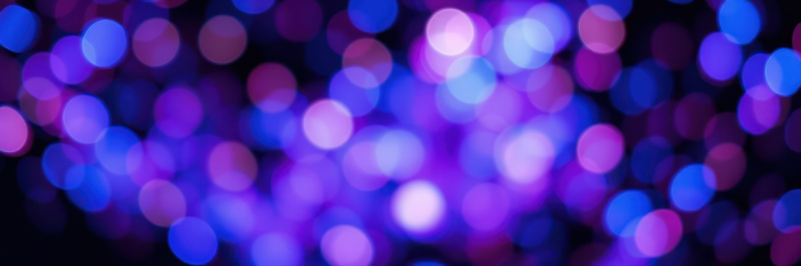 Colorful abstract background with vibrant purple and blue bokeh lights creating a festive atmosphere during nighttime events